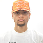Model  wearing an orange cap trucker hat  and white  signature t-shirt