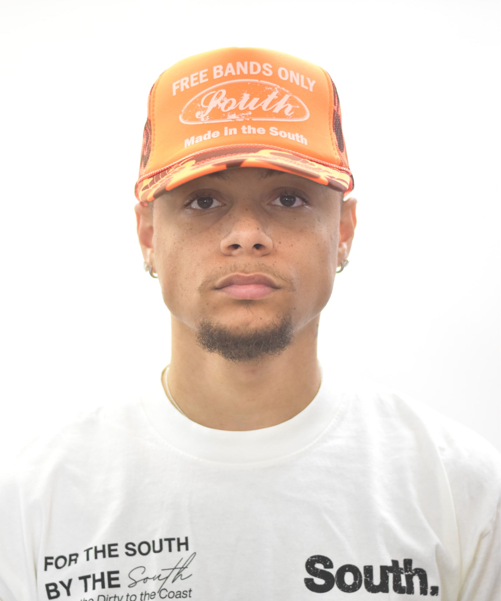 Model  wearing an orange cap trucker hat  and white  signature t-shirt